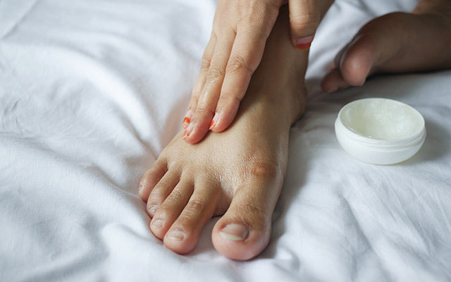 Women Applying petroleum jelly onto feet